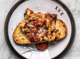 For a quick, flavorful, and light lunch, this Garlic Toast with Blistered Tomatoes and White Beans hits the spot! BudgetBytes.com