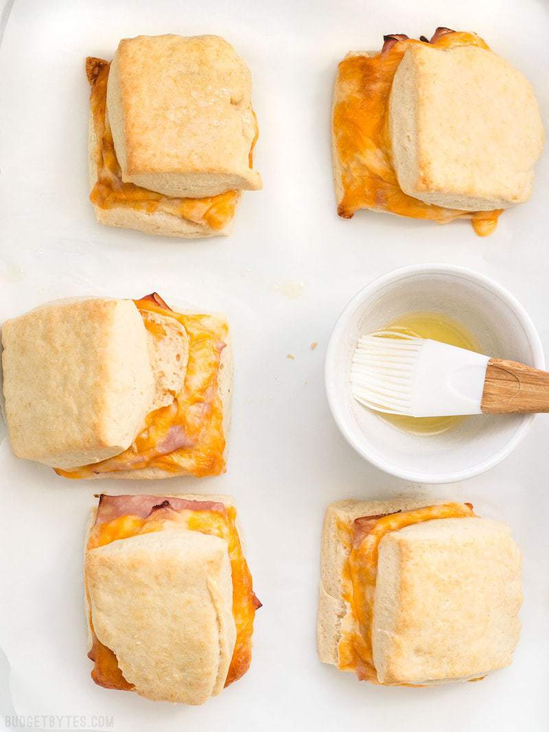 Six Ham and Cheese Biscuits being brushed with melted butter