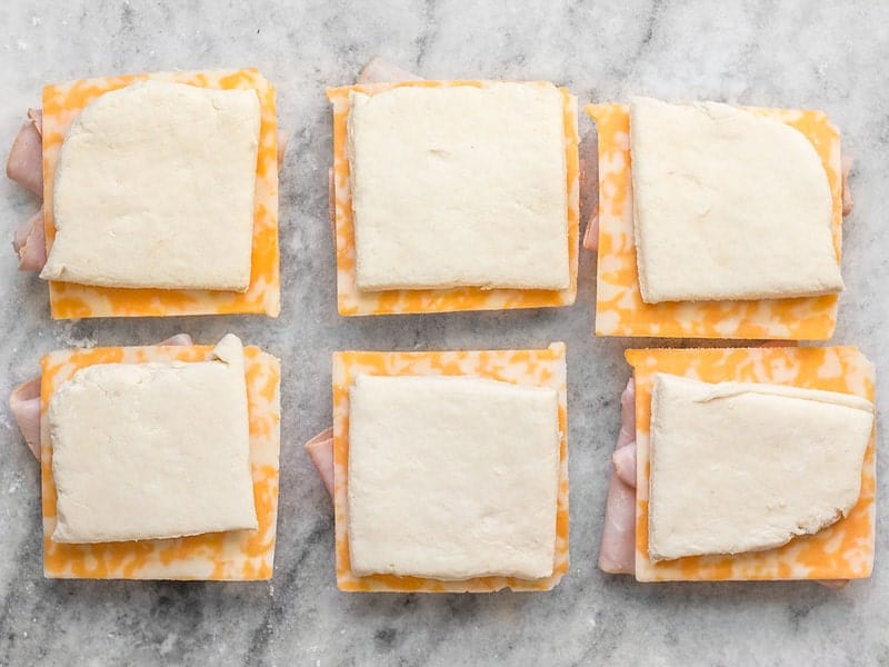 Top biscuits with ham and cheese slices