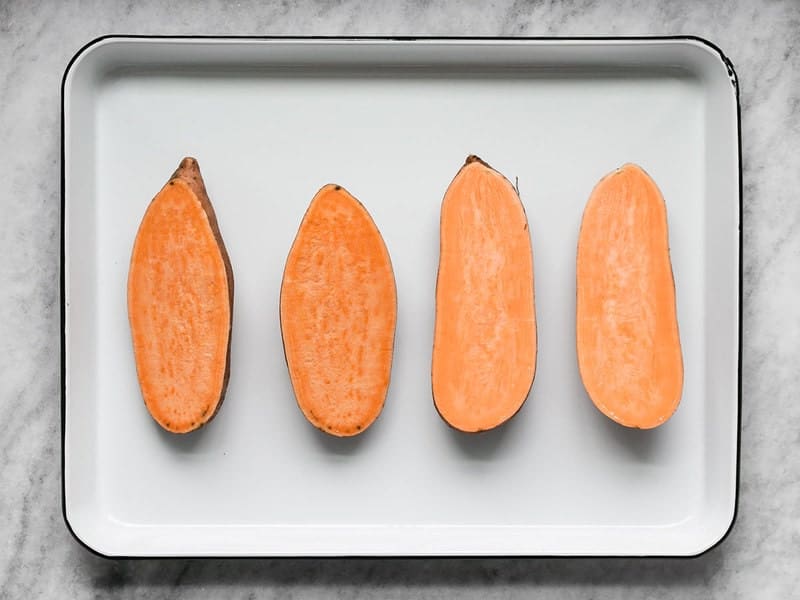 Four Sweet Potato Halves on a baking sheet