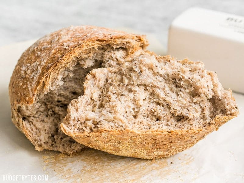 A loaf of Seeded No-Knead Bread torn in half. 