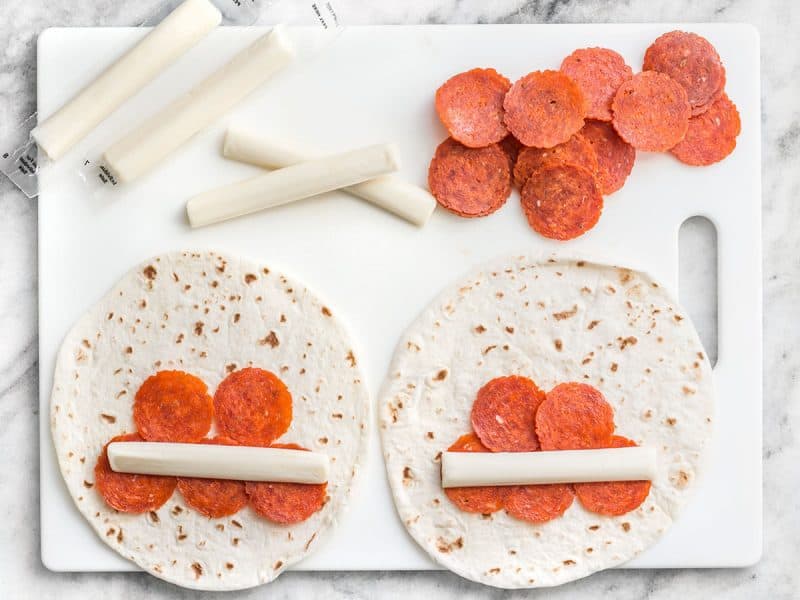 Pizza Roll Ups being filled and rolled