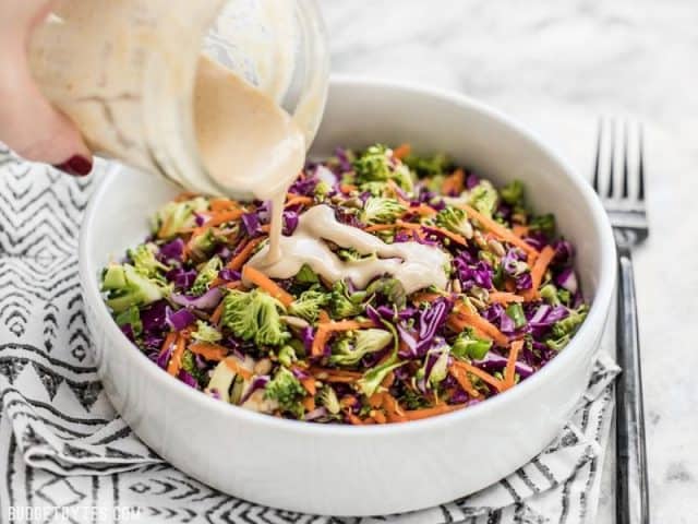 Dressing being poured onto Sweet Crunch Winter Salad