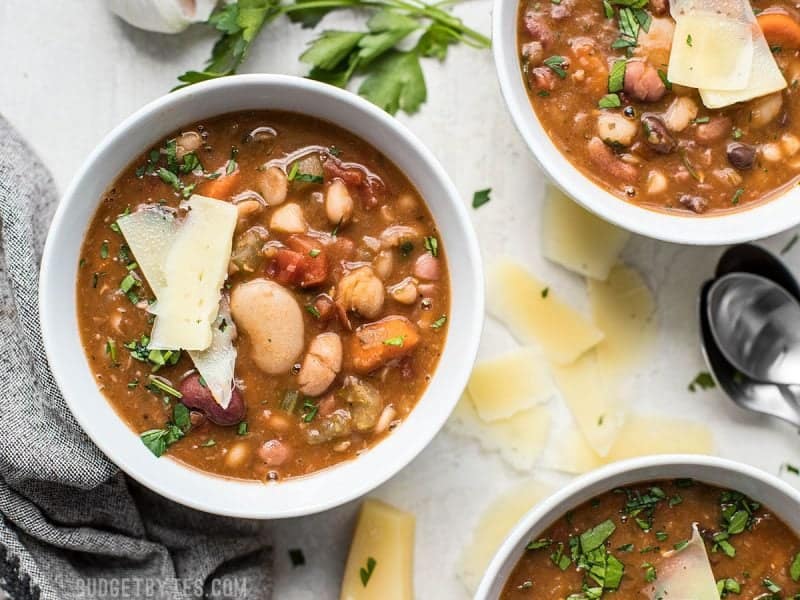 Three bowls of Vegetarian 15 Bean Soup with slices of parmesan and parsley