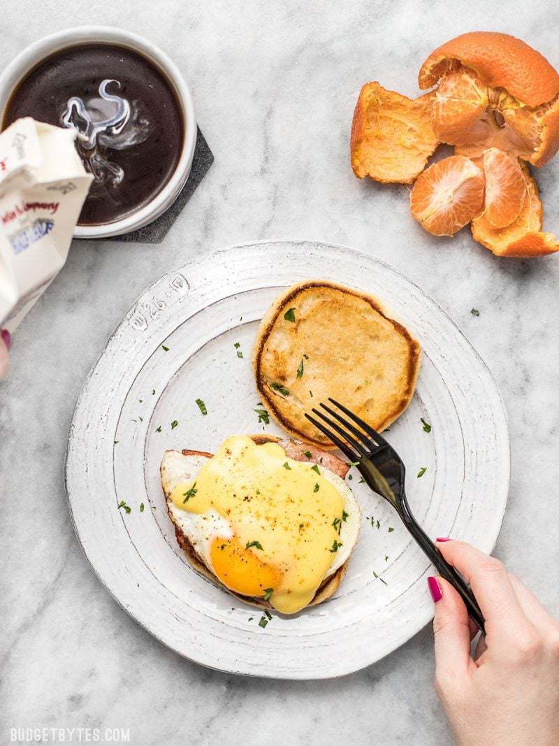 Almost Eggs Benedict being eaten with a cup of coffee and a tangerine