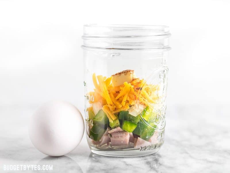 Make Ahead Microwave Breakfast Scrambles are a fast, easy, and healthy breakfast when you’re short on time! BudgetBytes.com A jar full of ingredients for Make Ahead Microwave Breakfast Scrambles