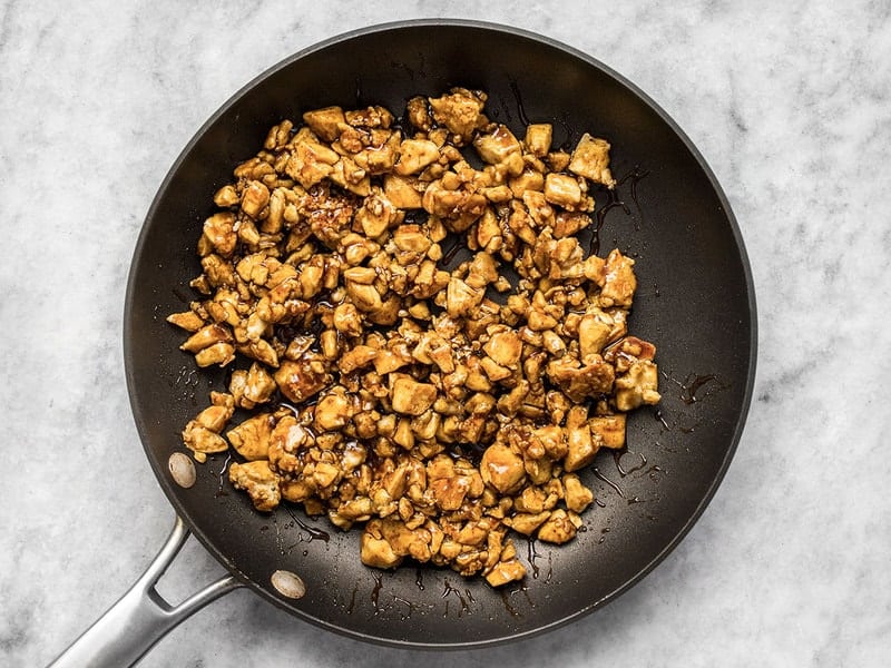 Fried tofu pieces coated in hoisin sauce in the skillet