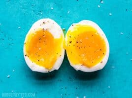 a soft boiled egg cut in half on a blue background