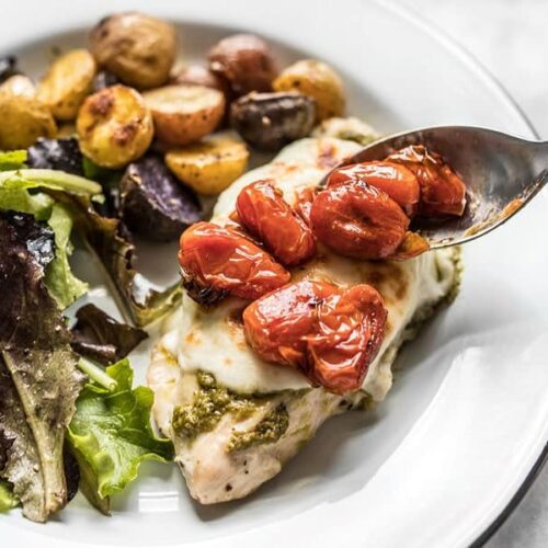 Close up of roasted tomatoes on top of Sheet Pan Pesto Chicken DInner