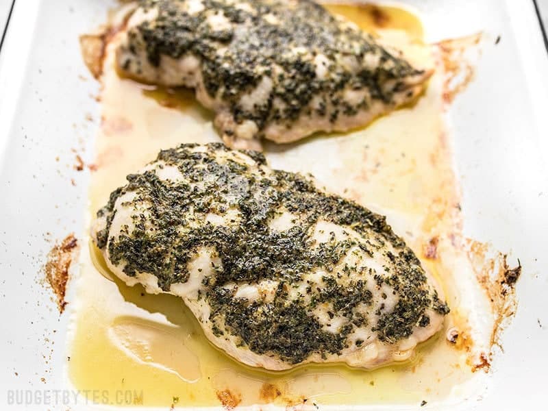 Garlic Herb Baked Chicken Breast in baking dish with juices.