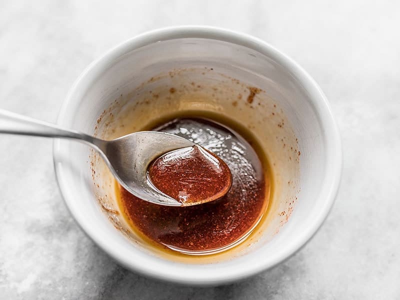 Mixed smoky maple glaze in a small bowl with a spoon.