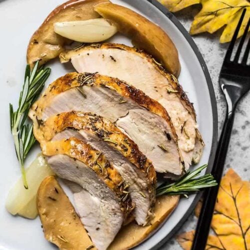 Sliced Cider Roasted Turkey Breast on the plate with apples and onions