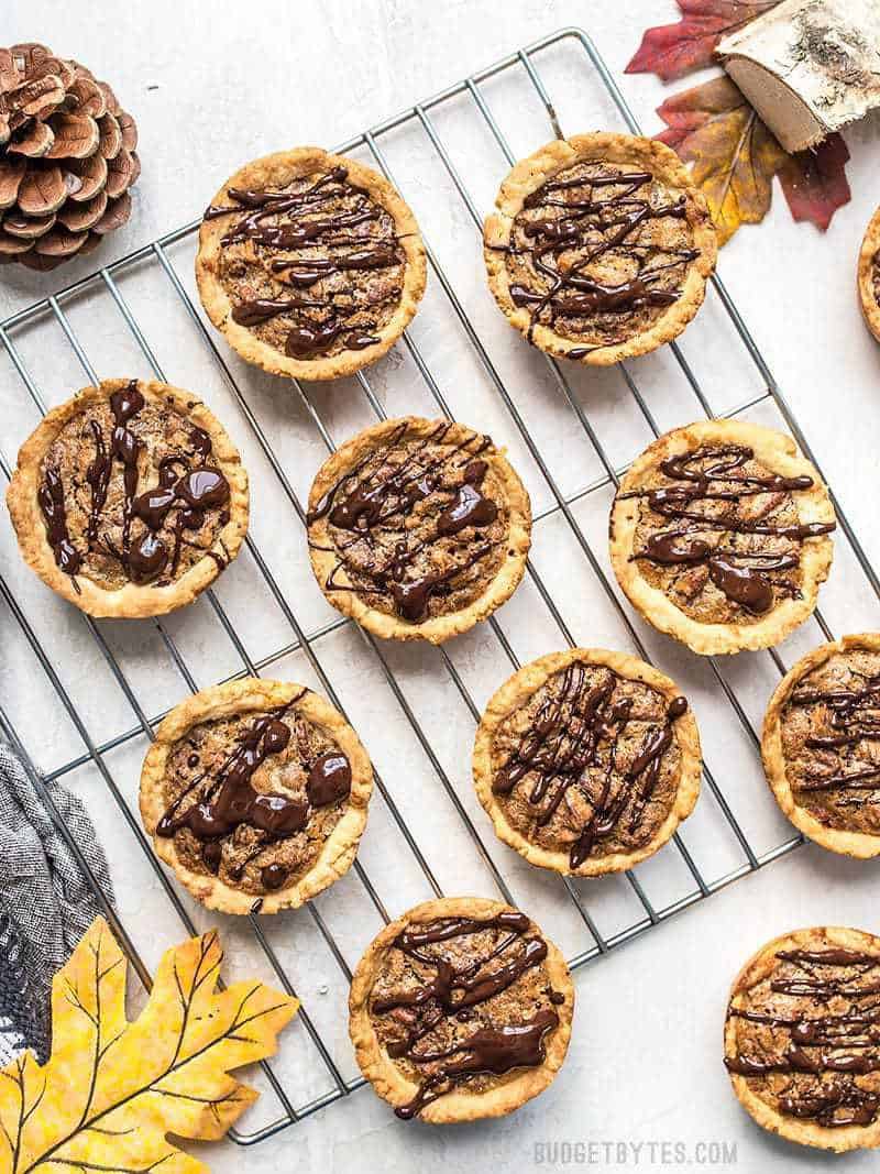 Mini Dark Chocolate Pecan Pies on a cooling rack ready to eat.