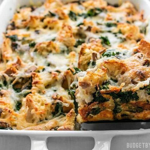 One slice being lifted from a pan of freshly baked Kale Swiss and Mushroom Strata