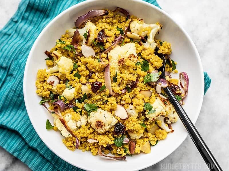 A bowl of Roasted Cauliflower and Quinoa Salad on a teal napkin.