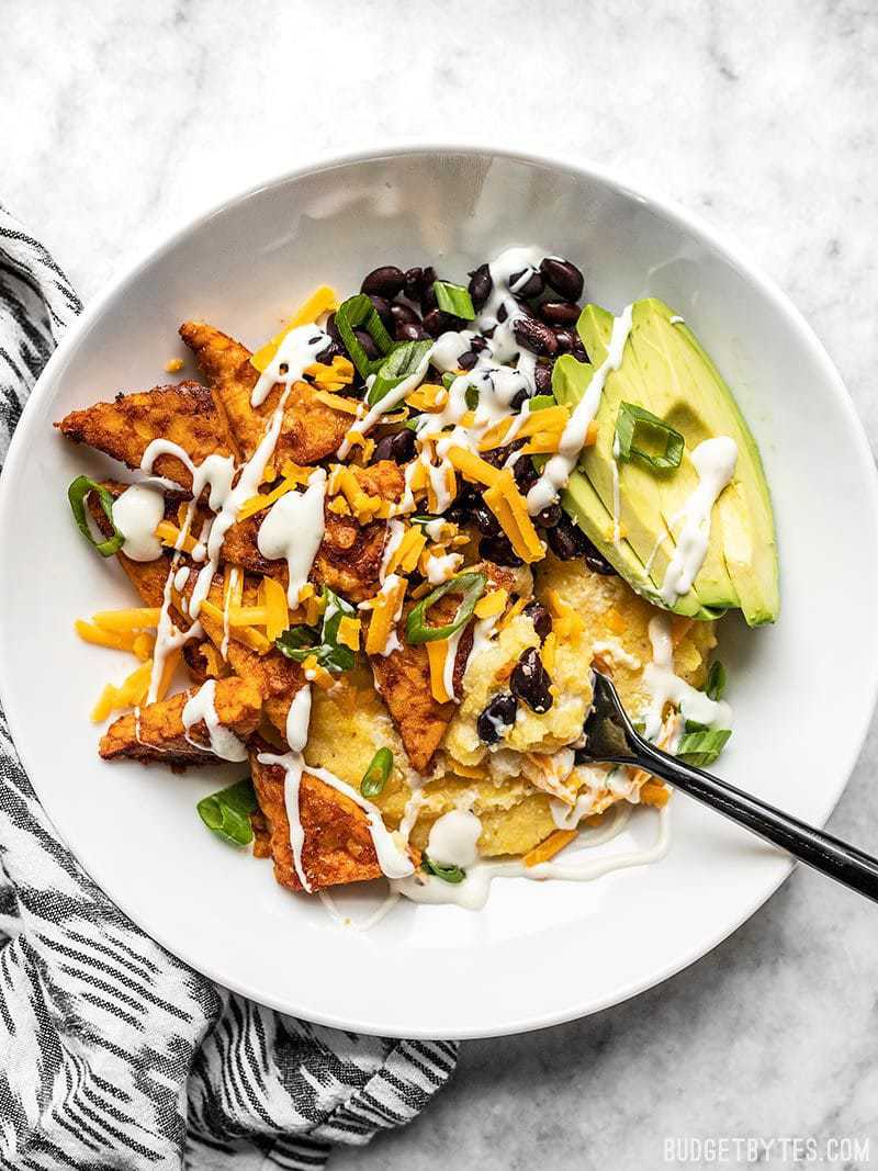 A Sweet and Spicy Tempeh bowl with a ranch drizzle, about to be eaten.