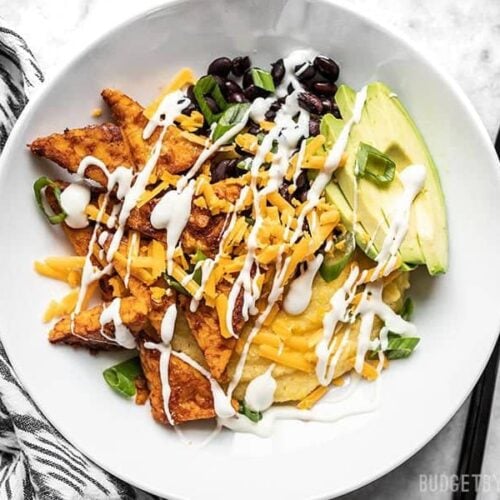 A prepared Sweet and Spicy Tempeh Bowl with ranch drizzle.