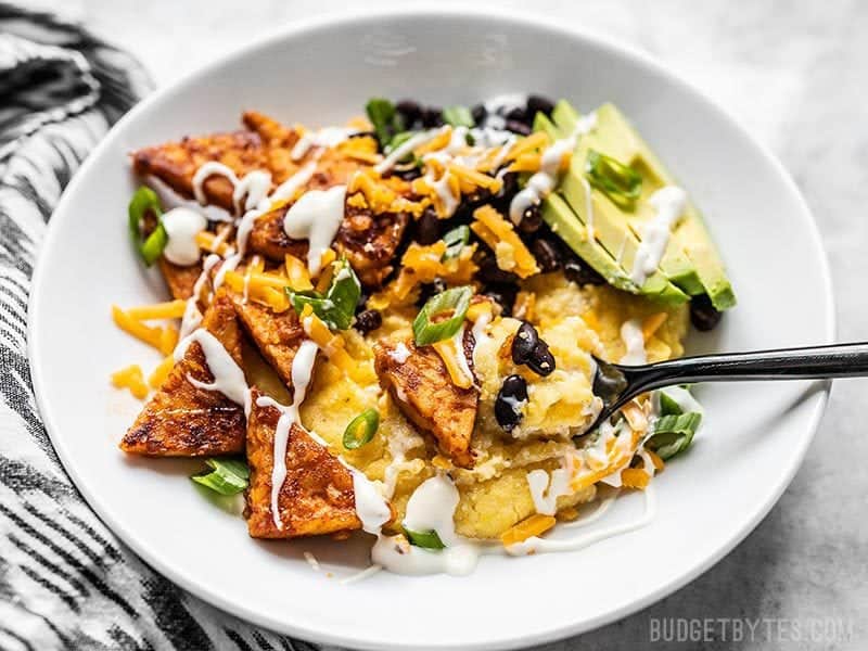 A Sweet and Spicy Tempeh Bowl being eaten, front view.