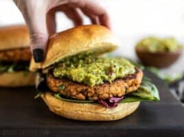 Cajun Salmon Burgers topped with guacamole and the top half of a bun