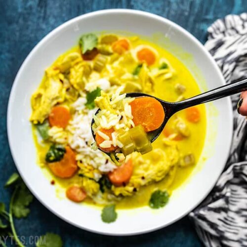 Close up of a spoonful of Coconut Turmeric Chicken Soup