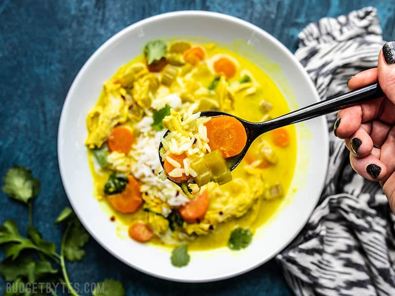 Close up of a spoonful of Coconut Turmeric Chicken Soup