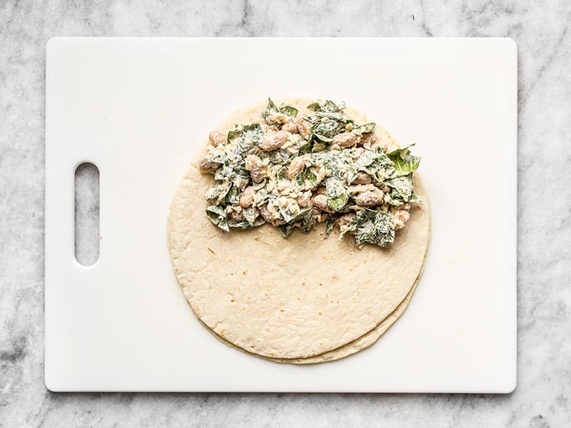 Flour tortilla with spinach and bean mixture covering half