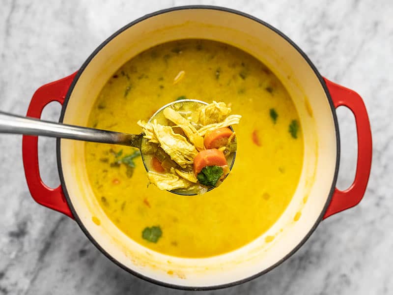 Finished Coconut Turmeric Chicken Soup in a ladle