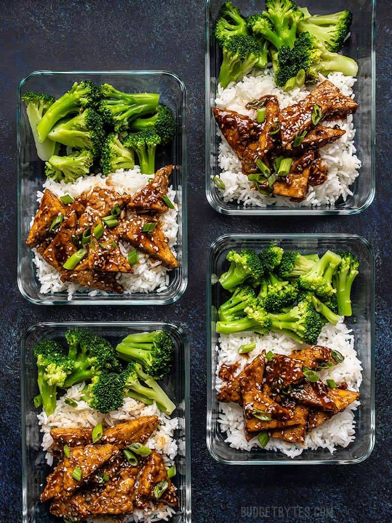 Four glass meal prep containers full of Sesame Tempeh Bowls