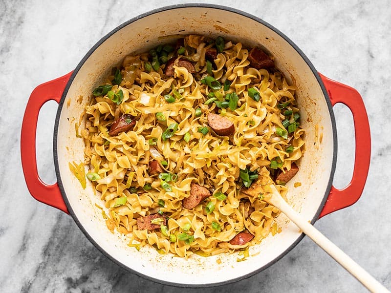 Finished Cajun Cabbage and Noodles in the pot with green onions on top.