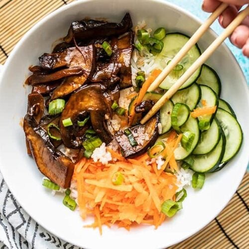 Mushrooms being picked up with chopsticks out of a Gochujang Mushroom Bowl