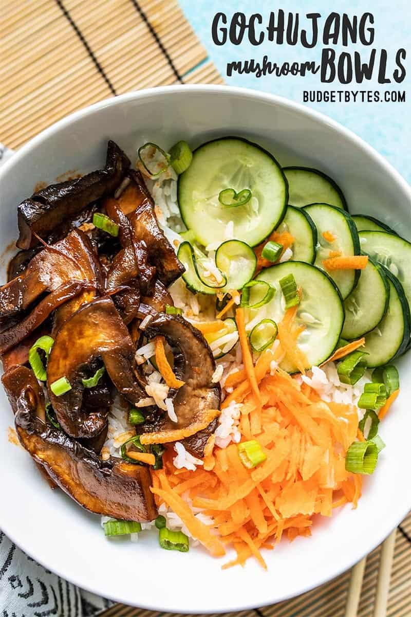 Close up overhead shot of a Gochujang Mushroom Bowl on a bamboo mat with a patterned napkin.