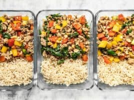 Three rectangular glass meal prep containers with Ground Turkey Stir Fry and Brown Rice