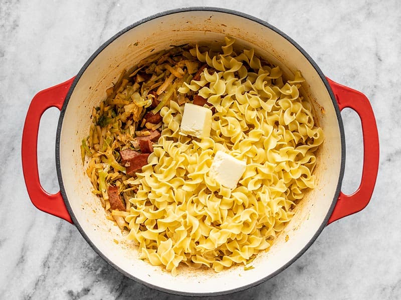 Noodles and Butter added to the pot with wilted cabbage and sausage.