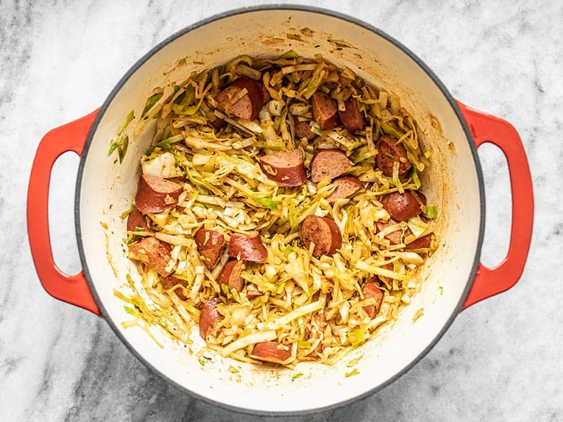 Wilted cabbage and sausage in the pot.