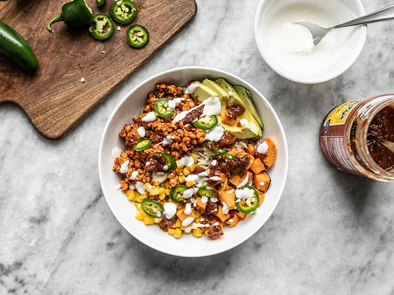 Finished Tempeh Burrito Bowl, topped with sour cream.