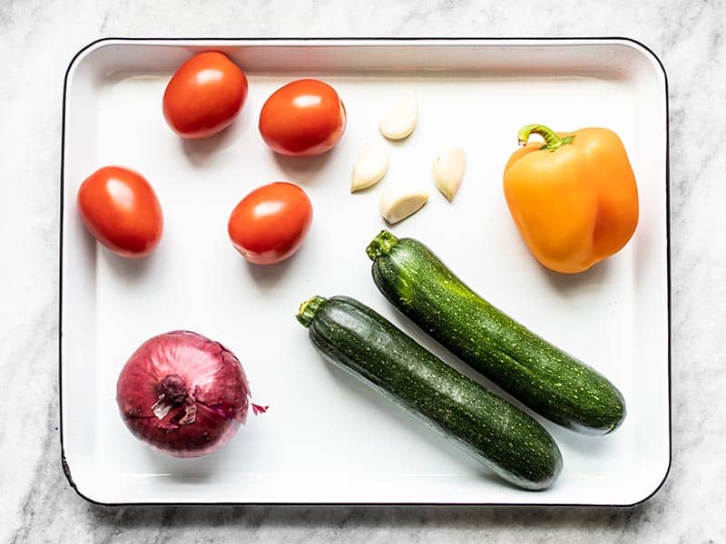 Whole vegetables for roasted vegetable couscous, on baking sheet