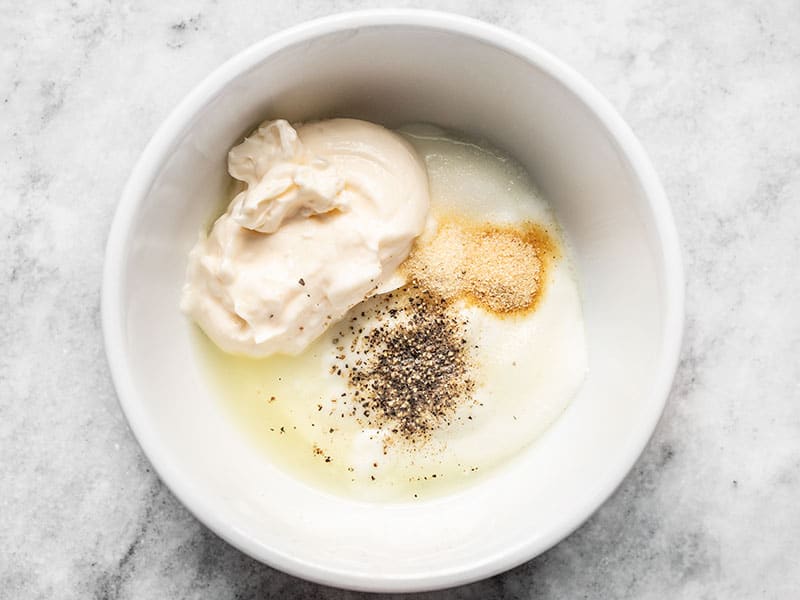 Homemade Ranch Dressing ingredients in a bowl, except the fresh herbs