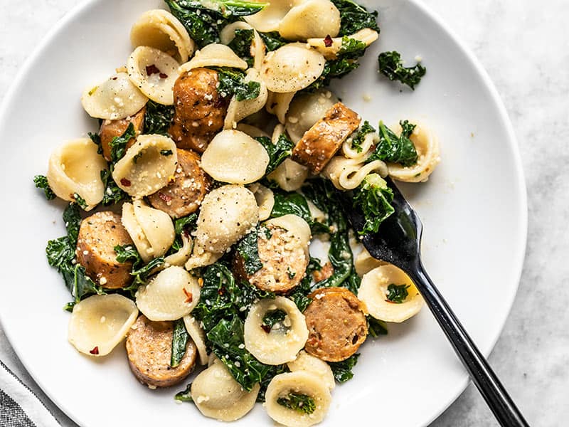 Overhead view of a shallow bowl full of Spicy Orecchiette with Chicken Sausage and Kale