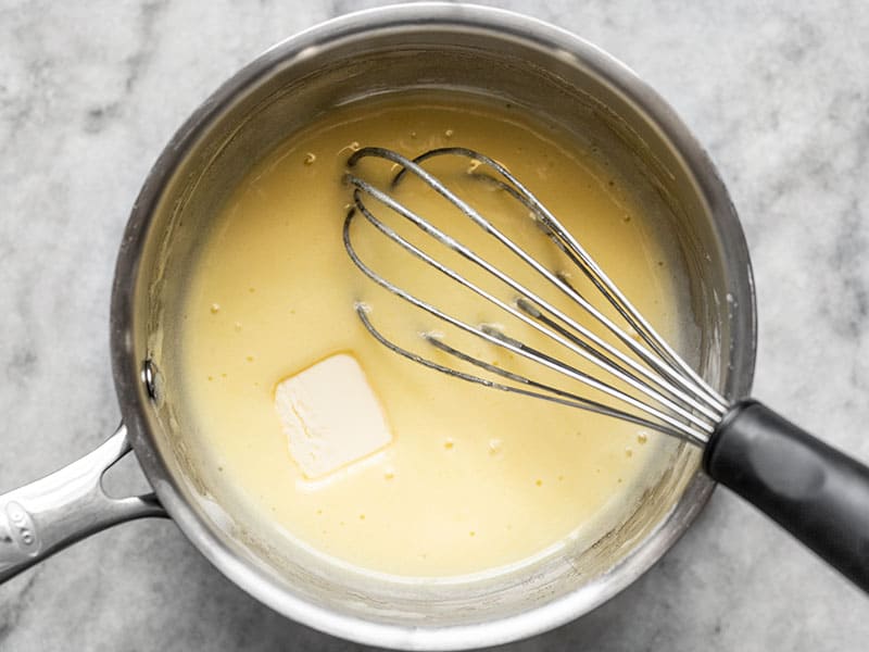 One tablespoon of butter added to the pot, about to be whisked in.