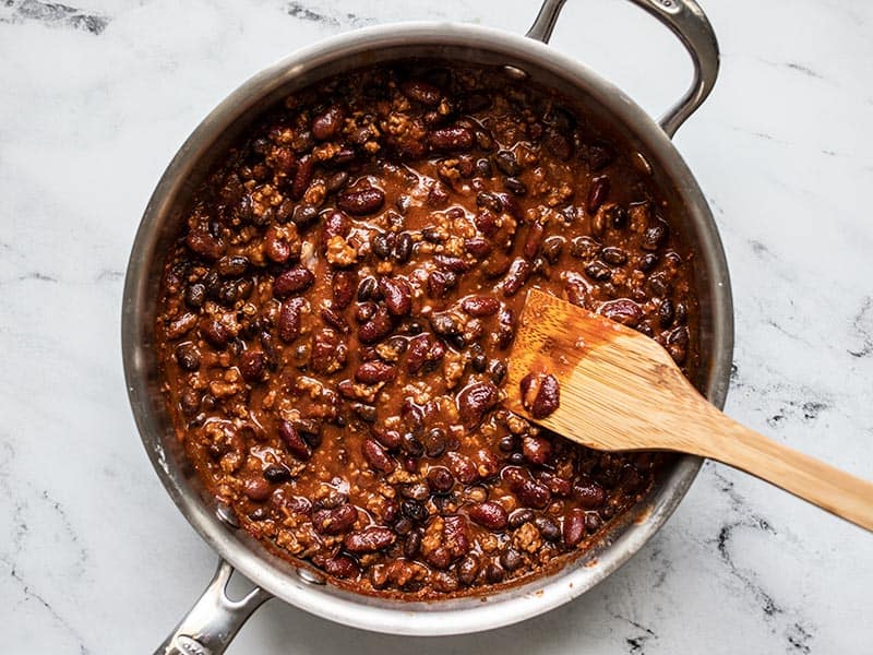 Finished BBQ Beef and Beans in the skillet with a wooden spatula