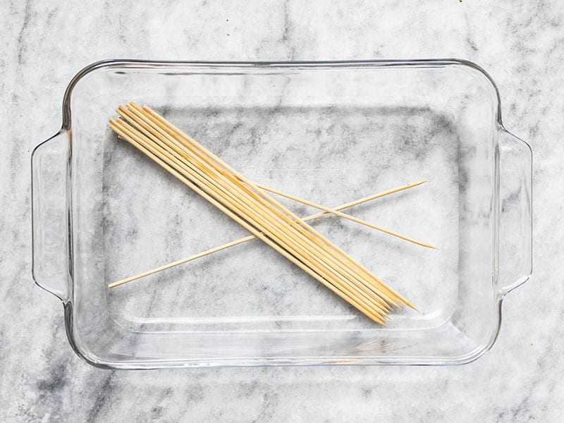 Wooden kebab skewers soaking in a dish of water