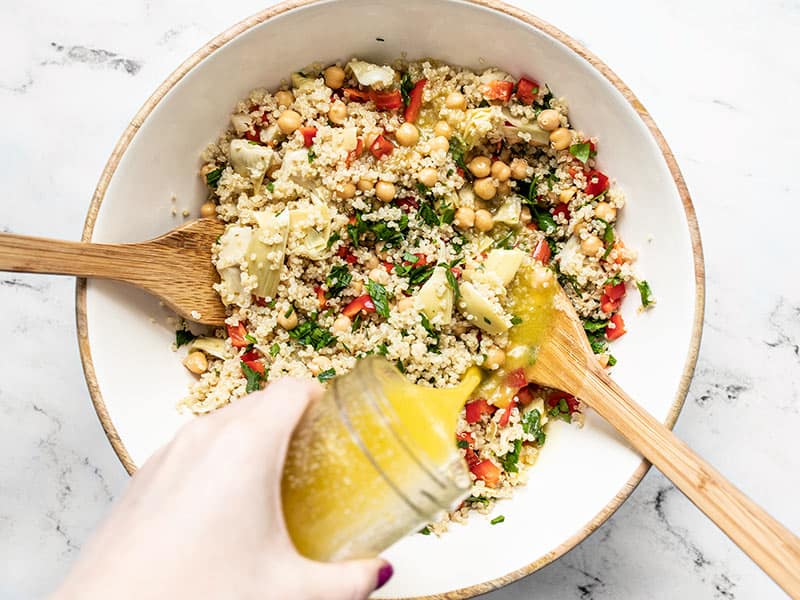 Lemon garlic dressing being poured over the salad bowl