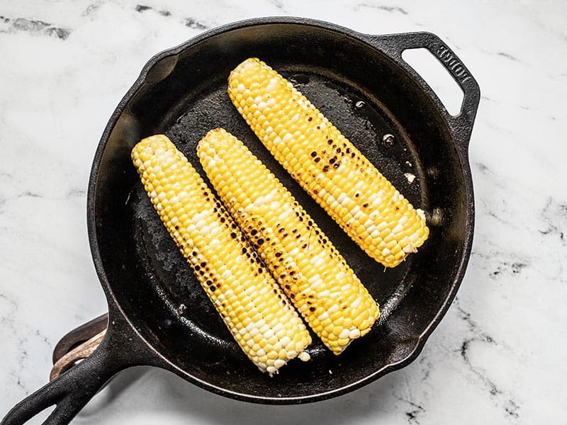 Charred corn cobs in a cast iron skillet