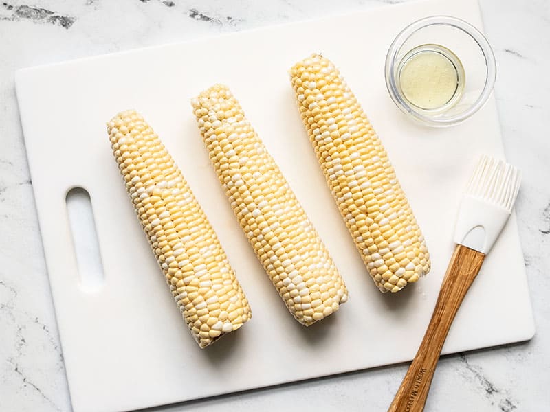 Cleaned corn cobs with oil brushed on the surface.