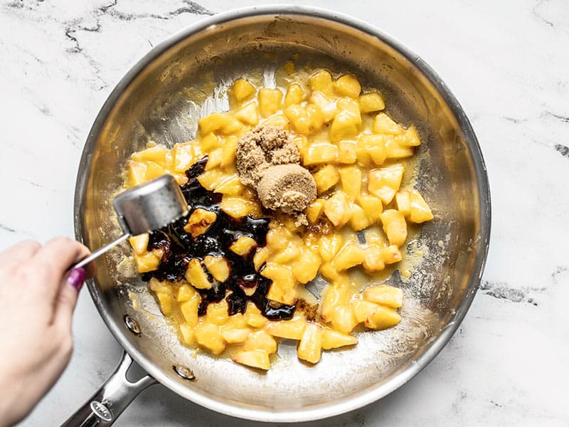 Adding brown sugar and balsamic vinegar to peaches in skillet