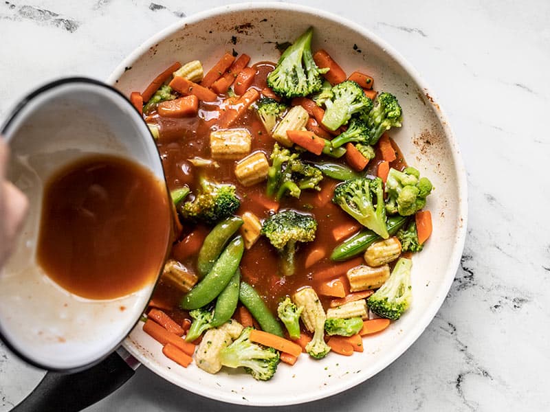 Add frozen vegetables and sweet and sour sauce to the skillet.