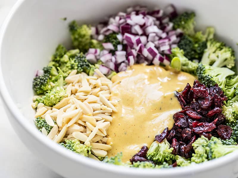 Close up side view of the Honey Mustard Broccoli Salad ingredients in the bowl before they are mixed.