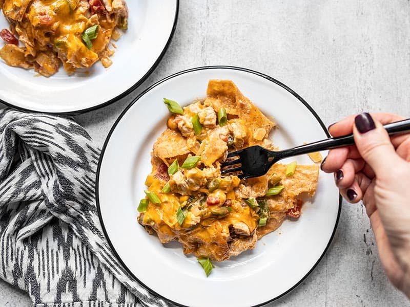 Two plates with King Ranch Chicken Casserole, a fork digging into one of them.