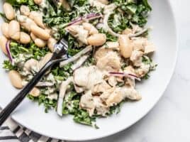 Close up of Lemon Dill Salmon and Kale Salad on a plate with a black fork