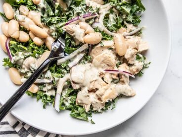 Close up of Lemon Dill Salmon and Kale Salad on a plate with a black fork